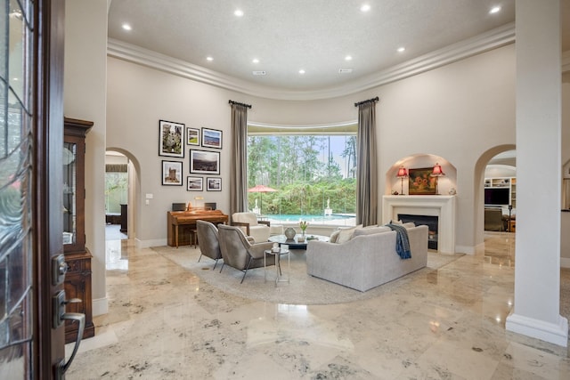 11 Bracebridge Dr, The Woodlands, TX 77382 - living area with arched walkways, crown molding, a high ceiling, marble tiled floors, and a fireplace