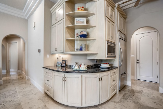11 Bracebridge Dr, The Woodlands, TX 77382 - kitchen featuring arched walkways, appliances with stainless steel finishes, baseboards, open shelves, and dark stone countertops