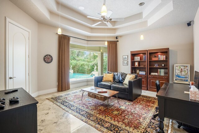 11 Bracebridge Dr, The Woodlands, TX 77382 - living area with a raised ceiling, ceiling fan, a textured ceiling, a desk, and baseboards