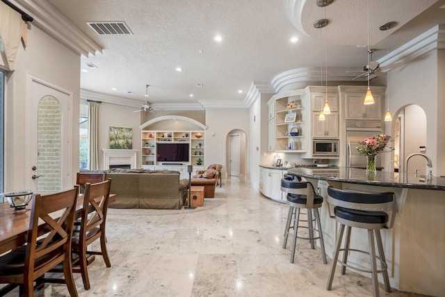 11 Bracebridge Dr, The Woodlands, TX 77382 - kitchen featuring ceiling fan, built in appliances, arched walkways, open shelves, and recessed lighting