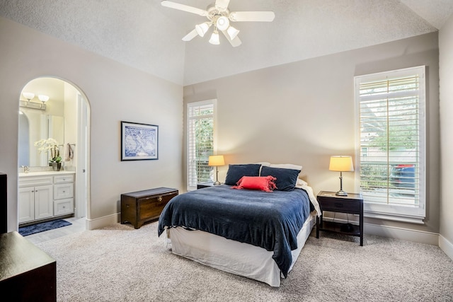 11 Bracebridge Dr, The Woodlands, TX 77382 - carpeted bedroom with lofted ceiling, baseboards, ensuite bath, arched walkways, and a ceiling fan