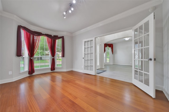 17862 Camp Cove Dr, Cypress, TX 77429 - empty room with french doors, wood finished floors, arched walkways, baseboards, and ornamental molding