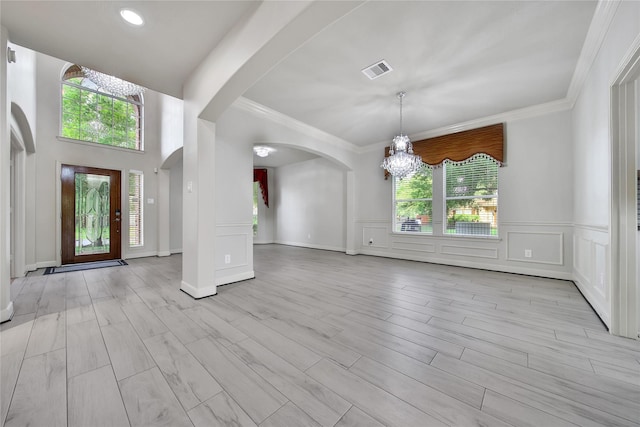 17862 Camp Cove Dr, Cypress, TX 77429 - foyer entrance featuring a chandelier, arched walkways, plenty of natural light, crown molding, and a decorative wall