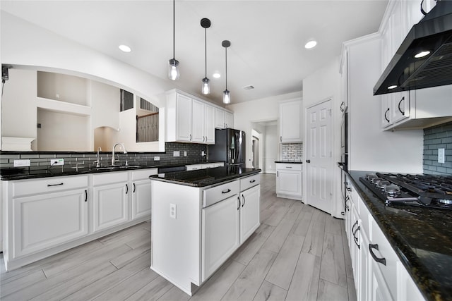 17862 Camp Cove Dr, Cypress, TX 77429 - kitchen featuring wall chimney range hood, black appliances, a sink, a center island, and tasteful backsplash