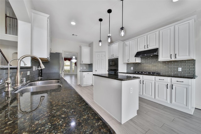 17862 Camp Cove Dr, Cypress, TX 77429 - kitchen with a sink, black appliances, under cabinet range hood, decorative backsplash, and white cabinets