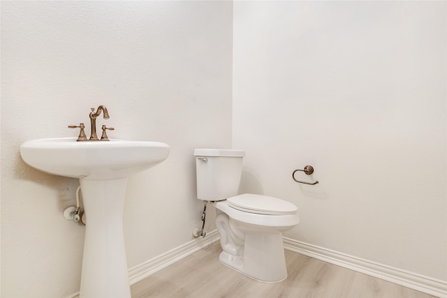 14339 Tasmania Ct, Sugar Land, TX 77498 - half bathroom with toilet, wood finished floors, baseboards, and a sink