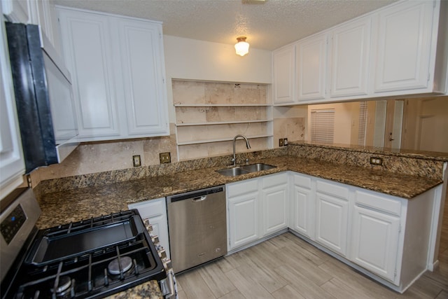 17647 Seven Pines Dr, Spring, TX 77379 - kitchen featuring appliances with stainless steel finishes, a sink, white cabinetry, open shelves, and a peninsula
