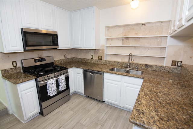 17647 Seven Pines Dr, Spring, TX 77379 - kitchen with stainless steel appliances, a sink, open shelves, white cabinets, and a textured ceiling