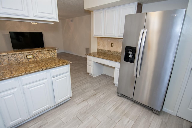 17647 Seven Pines Dr, Spring, TX 77379 - kitchen with stainless steel fridge, white cabinetry, dark stone counters, a textured ceiling, and light wood-style flooring