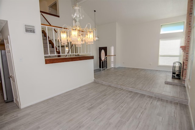 17647 Seven Pines Dr, Spring, TX 77379 - unfurnished living room with wood finished floors, stairs, a chandelier, high vaulted ceiling, and baseboards