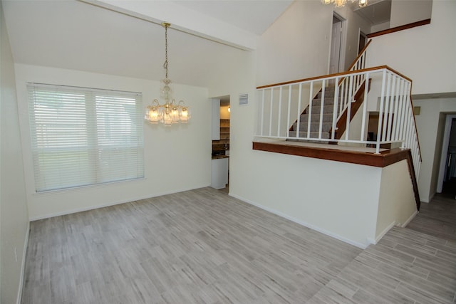 17647 Seven Pines Dr, Spring, TX 77379 - unfurnished living room featuring a chandelier, stairs, wood finished floors, vaulted ceiling, and baseboards