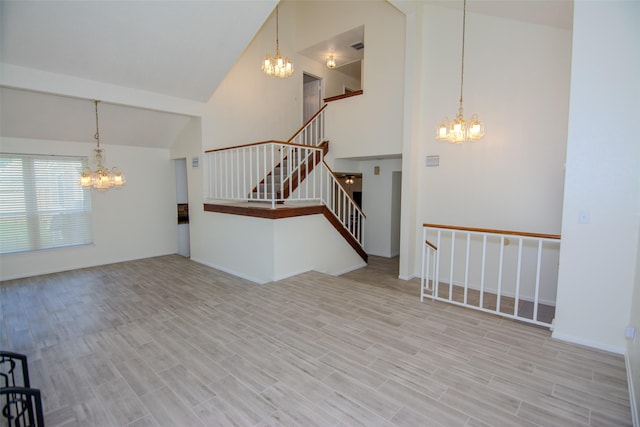 17647 Seven Pines Dr, Spring, TX 77379 - unfurnished living room featuring a chandelier, high vaulted ceiling, stairs, and wood finished floors