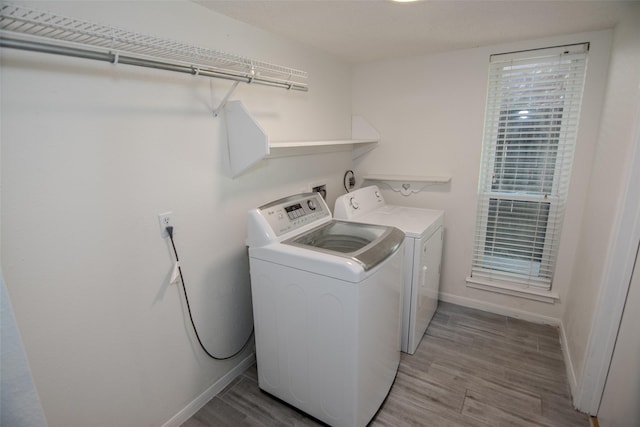 17647 Seven Pines Dr, Spring, TX 77379 - washroom featuring washer and clothes dryer, baseboards, and light wood-style flooring