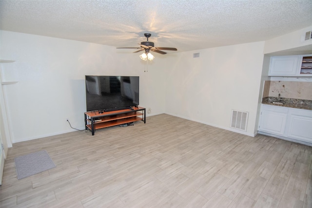 17647 Seven Pines Dr, Spring, TX 77379 - living area with ceiling fan, light wood-style flooring, a textured ceiling, and baseboards