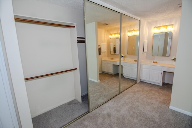 17647 Seven Pines Dr, Spring, TX 77379 - bathroom with double vanity, carpet flooring, a textured ceiling, and baseboards
