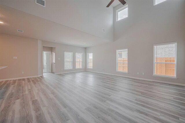 5819 Grantgrala Dr, Katy, TX 77493 - unfurnished room featuring ceiling fan, baseboards, light wood-style flooring, and a high ceiling
