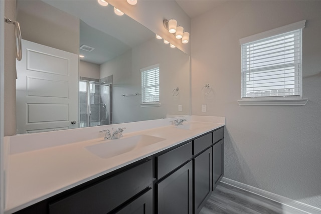5819 Grantgrala Dr, Katy, TX 77493 - full bathroom with baseboards, double vanity, a stall shower, and wood finished floors