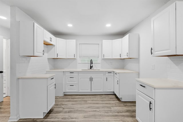 4002 Rutland St, Houston, TX 77018 - kitchen with a sink, light wood-style floors, backsplash, recessed lighting, and white cabinetry