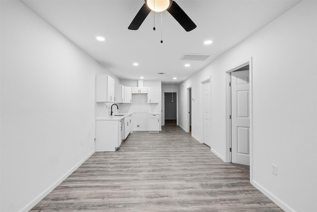 4002 Rutland St, Houston, TX 77018 - kitchen featuring ceiling fan, recessed lighting, white cabinets, a sink, and light wood finished floors