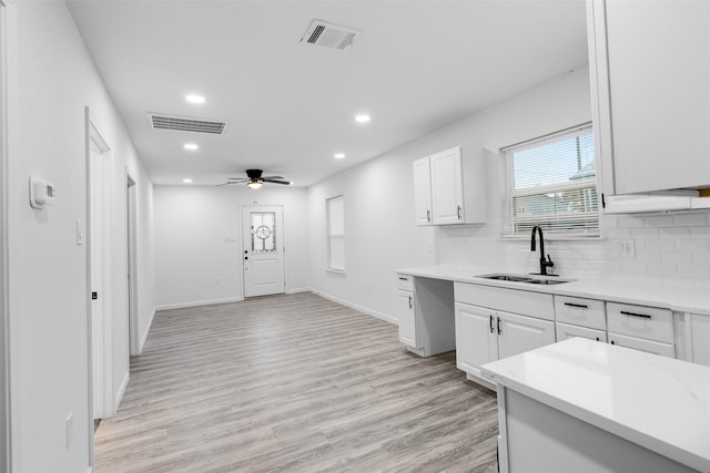 4002 Rutland St, Houston, TX 77018 - kitchen with a sink, recessed lighting, decorative backsplash, light wood-style flooring, and white cabinetry
