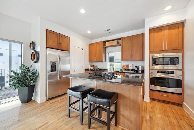 4502 Maxie St Unit A, Houston, TX 77007 - kitchen with stainless steel appliances, a center island, light wood-style flooring, a breakfast bar, and recessed lighting