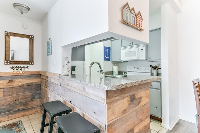 3506 Cove View Blvd Unit 506, Galveston, TX 77554 - kitchen with white appliances, light stone countertops, light tile patterned floors, and a sink