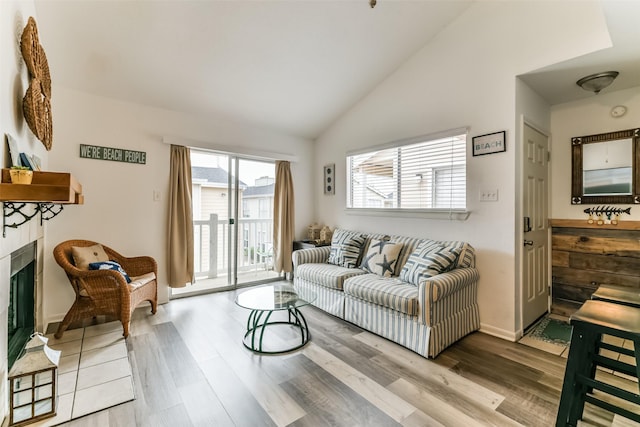 3506 Cove View Blvd Unit 506, Galveston, TX 77554 - living room with wood finished floors, a glass covered fireplace, baseboards, and high vaulted ceiling