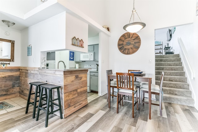 3506 Cove View Blvd Unit 506, Galveston, TX 77554 - kitchen with white appliances, light wood finished floors, a sink, a kitchen bar, and a peninsula