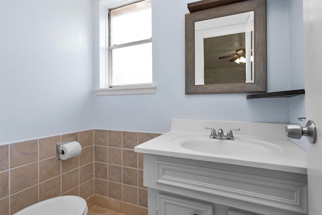 7322 Sawmill Trl, Houston, TX 77040 - bathroom featuring vanity, toilet, tile walls, and a ceiling fan