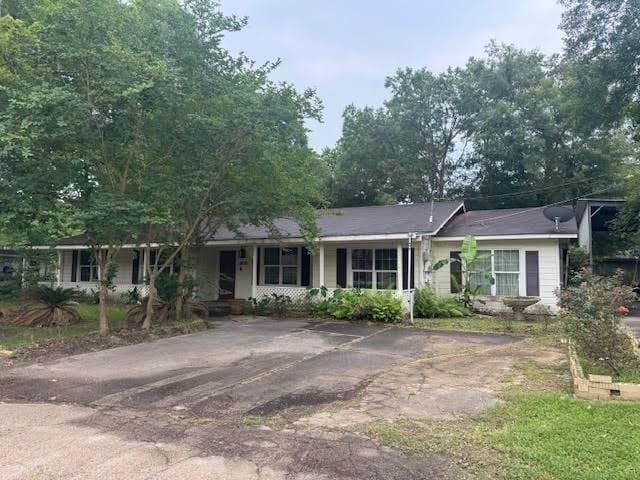 3475 Pelican St, Pinehurst, TX 77630 - ranch-style home featuring a porch and asphalt driveway