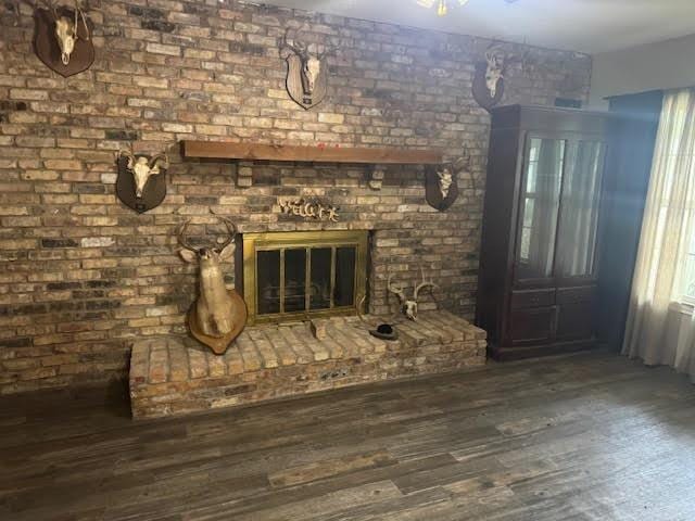 3475 Pelican St, Pinehurst, TX 77630 - unfurnished living room featuring wood finished floors and a brick fireplace
