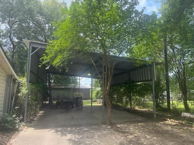 3475 Pelican St, Pinehurst, TX 77630 - view of vehicle parking with driveway and a carport