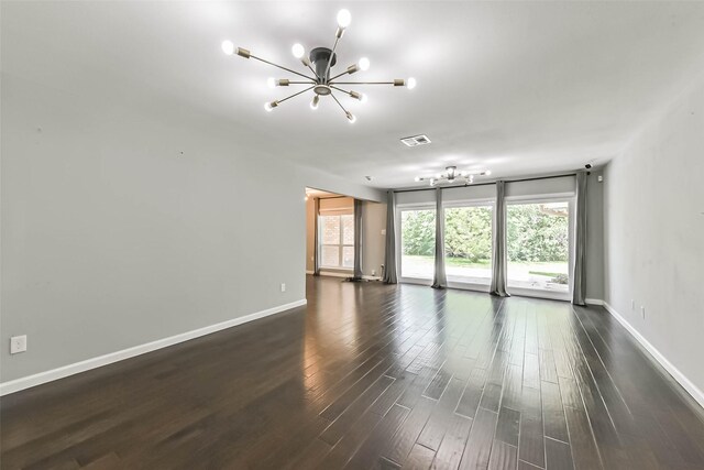 9207 Timberside Dr, Houston, TX 77025 - unfurnished living room with a chandelier, healthy amount of natural light, dark wood-style floors, and baseboards