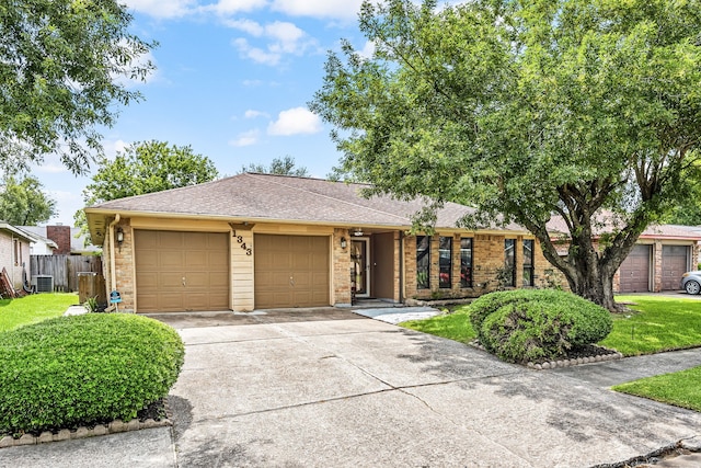 1343 Somercotes Ln, Channelview, TX 77530 - view of front of property with an attached garage, concrete driveway, a shingled roof, brick siding, and cooling unit