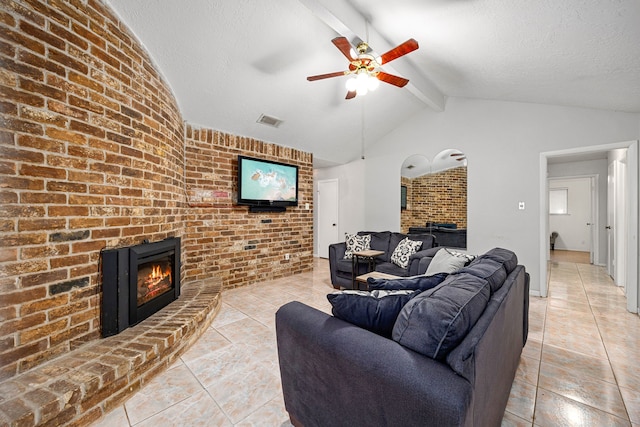 1343 Somercotes Ln, Channelview, TX 77530 - living room featuring a brick fireplace, ceiling fan, brick wall, light tile patterned flooring, and a textured ceiling