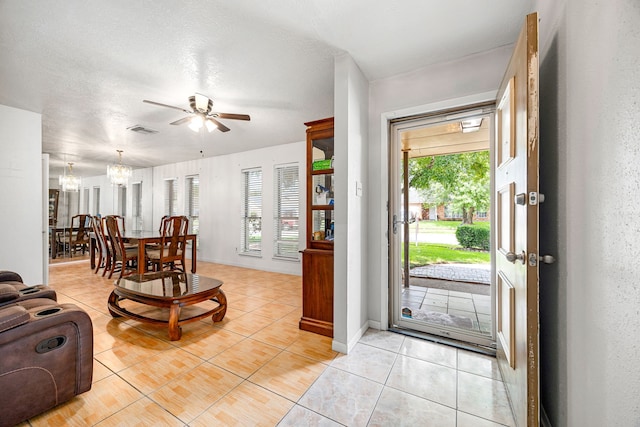 1343 Somercotes Ln, Channelview, TX 77530 - foyer entrance with ceiling fan, healthy amount of natural light, light tile patterned flooring, a chandelier, and a textured ceiling