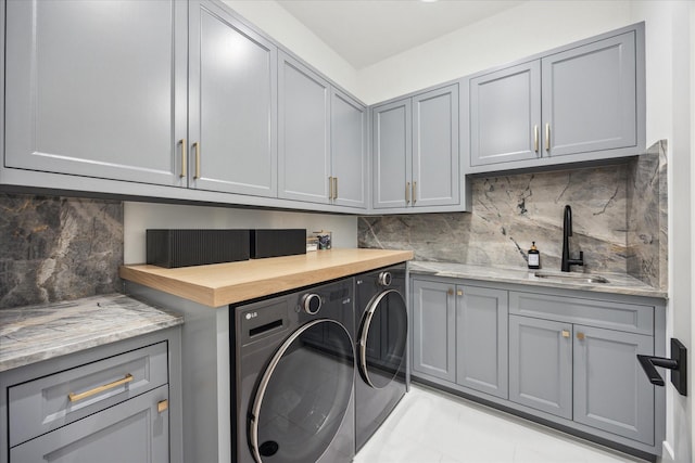 510 Wilmington Dr, Bellaire, TX 77401 - washroom with washing machine and clothes dryer, cabinet space, and light tile patterned floors