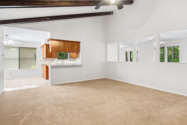 3811 Riverwood Park Dr, Houston, TX 77345 - unfurnished living room featuring a ceiling fan, light colored carpet, baseboards, high vaulted ceiling, and beam ceiling