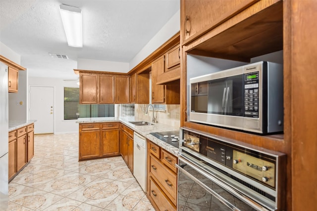 3811 Riverwood Park Dr, Houston, TX 77345 - kitchen featuring black appliances, a sink, brown cabinetry, tasteful backsplash, and light stone counters