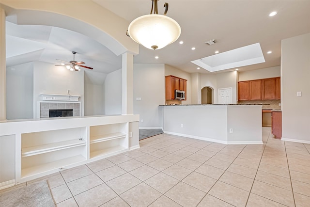 11519 Staffordale Ct, Cypress, TX 77433 - kitchen with stainless steel microwave, brown cabinets, a ceiling fan, light tile patterned floors, and recessed lighting