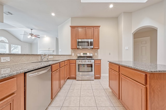 11519 Staffordale Ct, Cypress, TX 77433 - kitchen featuring appliances with stainless steel finishes, a sink, tasteful backsplash, a ceiling fan, and light tile patterned flooring