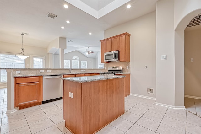 11519 Staffordale Ct, Cypress, TX 77433 - kitchen with stainless steel appliances, decorative backsplash, a center island, light stone counters, and a peninsula