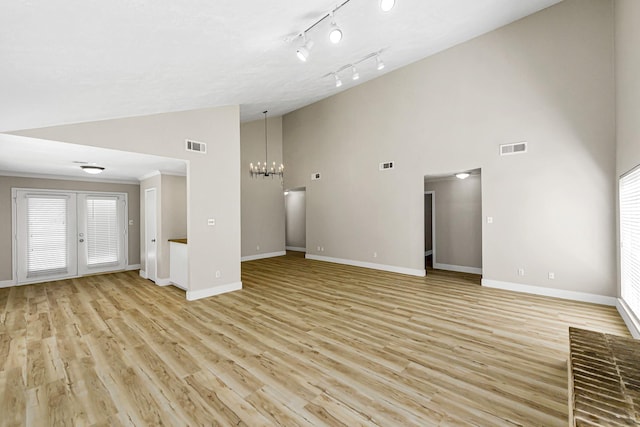 12014 Briar Forest Dr, Houston, TX 77077 - unfurnished living room with high vaulted ceiling, a chandelier, baseboards, light wood finished floors, and french doors