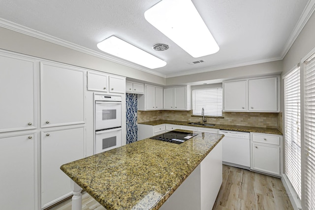 12014 Briar Forest Dr, Houston, TX 77077 - kitchen with white appliances, a sink, white cabinets, light wood finished floors, and crown molding
