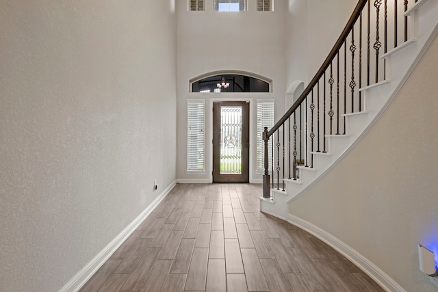 24714 Longwood Forest Dr, Spring, TX 77373 - entryway with baseboards, stairway, wood tiled floors, and a towering ceiling