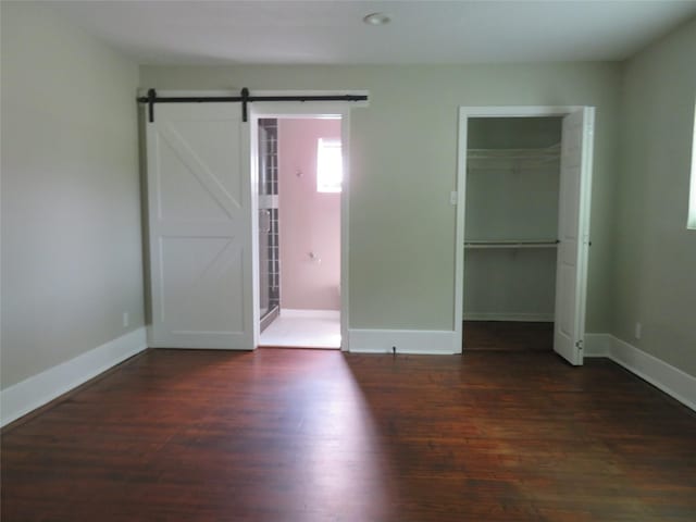 4801 Walker St, Houston, TX 77023 - unfurnished bedroom featuring wood finished floors, baseboards, a closet, and a barn door