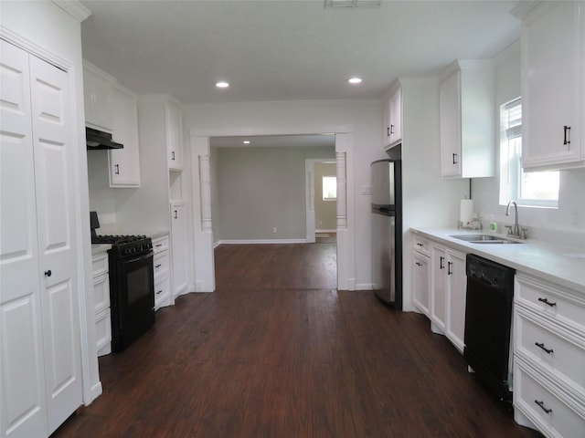 4801 Walker St, Houston, TX 77023 - kitchen with black appliances, a sink, under cabinet range hood, dark wood finished floors, and light countertops