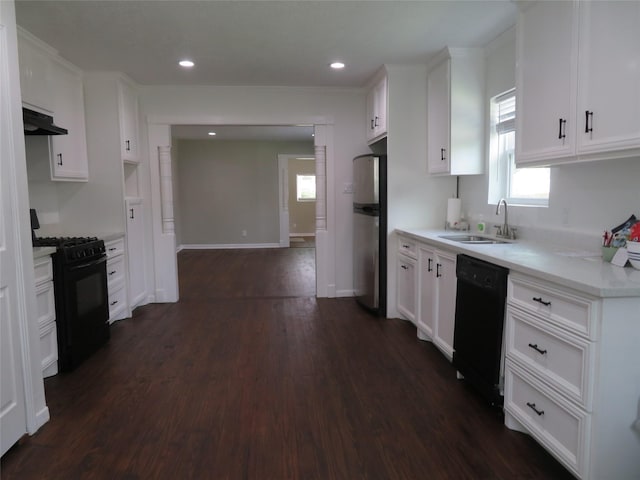 4801 Walker St, Houston, TX 77023 - kitchen with black appliances, a sink, under cabinet range hood, dark wood-type flooring, and white cabinets