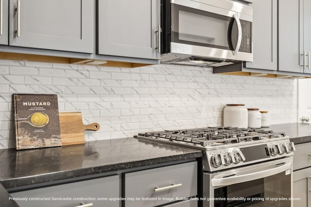 833 Fisher St Unit C, Houston, TX 77018 - kitchen with appliances with stainless steel finishes, tasteful backsplash, gray cabinets, and dark stone counters