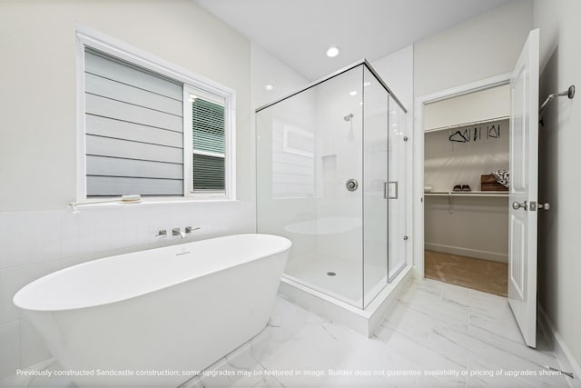 833 Fisher St Unit C, Houston, TX 77018 - full bathroom featuring a shower stall, a freestanding tub, a walk in closet, marble look tiles, and recessed lighting